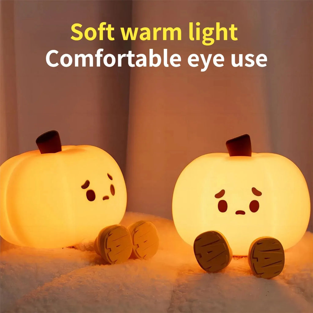 Pumpkin-shaped silicone night light with soft orange glow on wooden bedside table