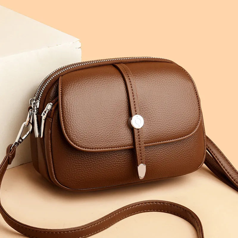 Women's crossbody shoulder bag in oval suitcase shape with soft PU construction