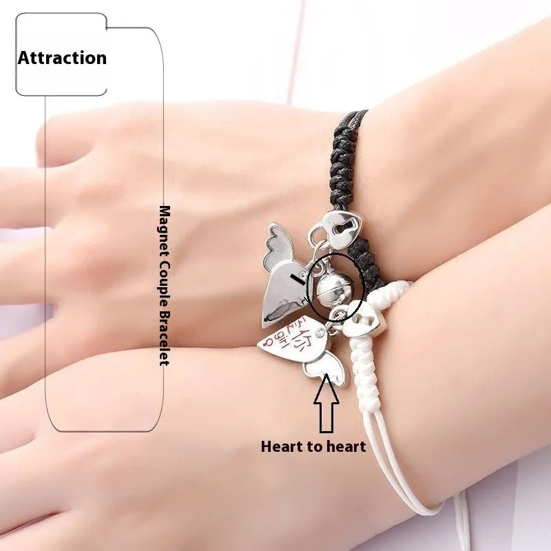 Pair of magnetic alloy bracelets with crown and heart charm designs on a wrist.