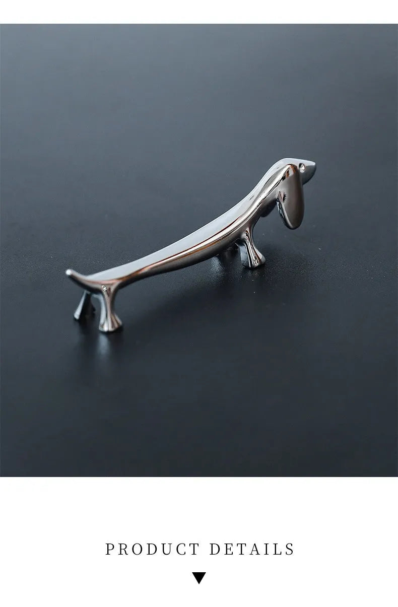 Silver zinc alloy sausage dog shaped chopstick rest on a table