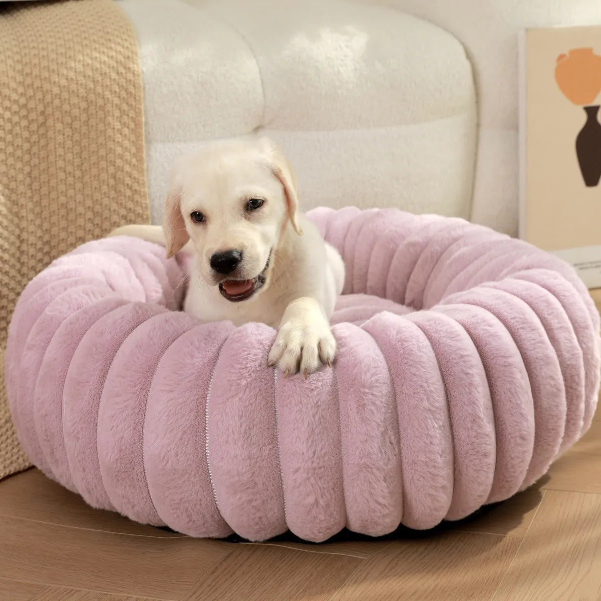 Soft beige rabbit plush round pet bed with high sides forming a nest, shown on a wooden floor.