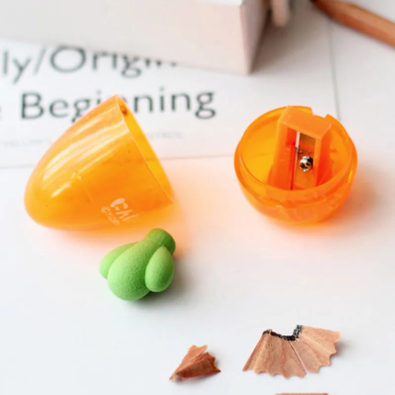 Orange carrot-shaped plastic pencil sharpener with green top, 7cm total length