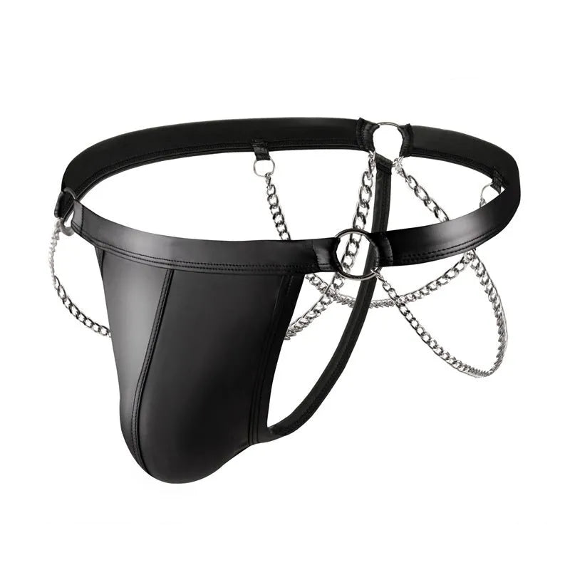 Black men's patent leather thong underwear with metal chain decoration on a grey background.