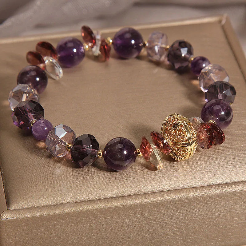 Purple crystal bracelet with pumpkin beads, wind chime charms, and rhinestone details on wrist