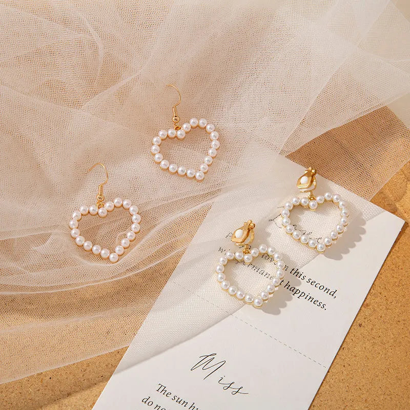 Heart shaped ear clip earrings for women with imitation pearl heart detail and retro round face, 1 pair