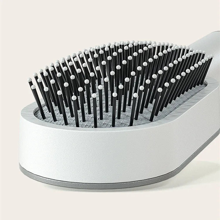 Self-cleaning hair brush with air cushion bristles in black gold, white, or purple colours