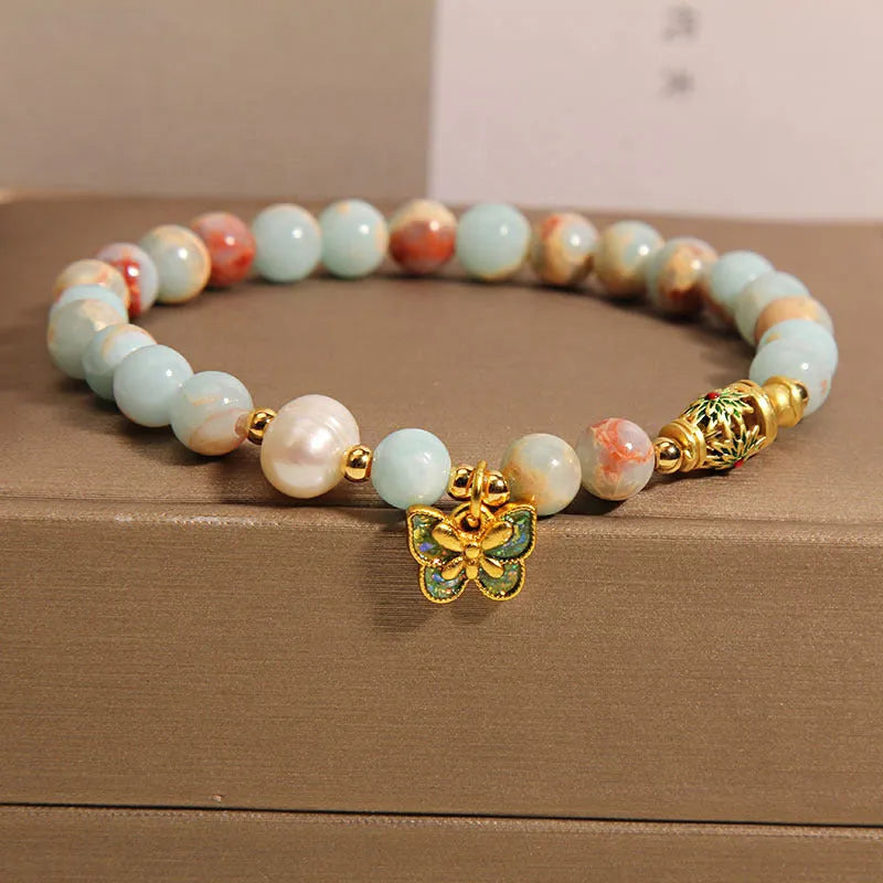 Blue women's bracelet with butterfly pendant containing Shoushan stone and freshwater pearls.