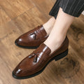 Men's black slip-on business casual shoe with tassel detail and rubber sole.