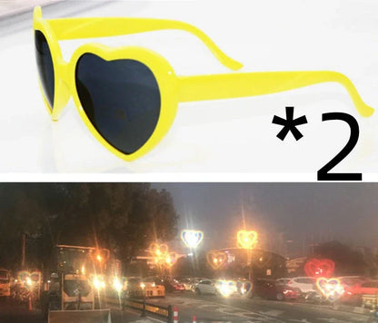 Heart-shaped glow-in-the-dark sunglasses in various vibrant colors, featuring a durable plastic frame and resin lenses for reliable UV protection.