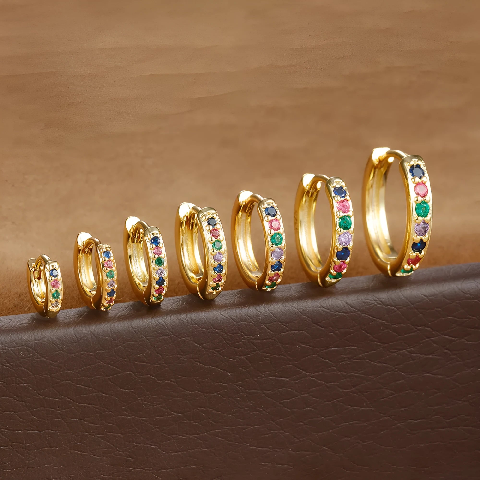 Perforated geometric circle stud earrings with zircon detail in gold, rose gold, and silver tones.