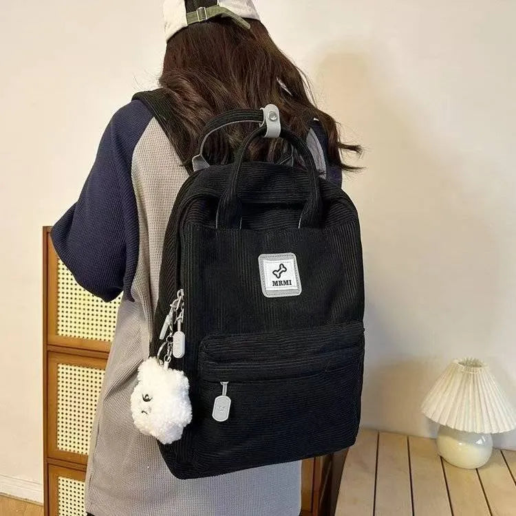 Retro hand-carrying backpack in light pink with breathable fabric, document pocket, and sewing line details for school use.