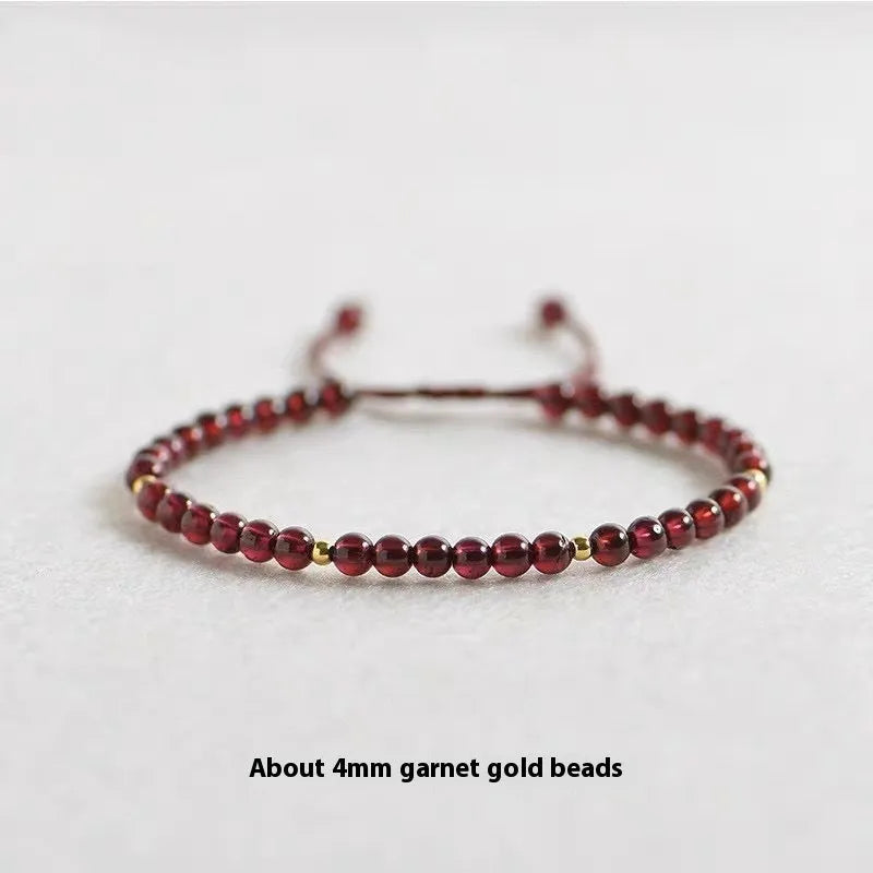 Hand-woven garnet bracelet with red rope and flexible wire construction showing national tide style