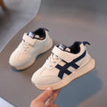 Children's white synthetic leather sneakers with Velcro fastening and textured rubber sole.
