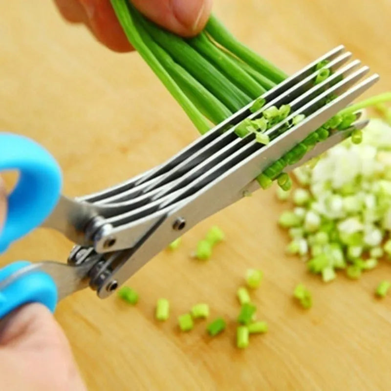 Stainless steel multi-blade kitchen scissors for cutting onions and herbs on a chopping board.