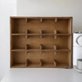 Square solid wood cup storage rack with multiple grids in natural birch wood colour.