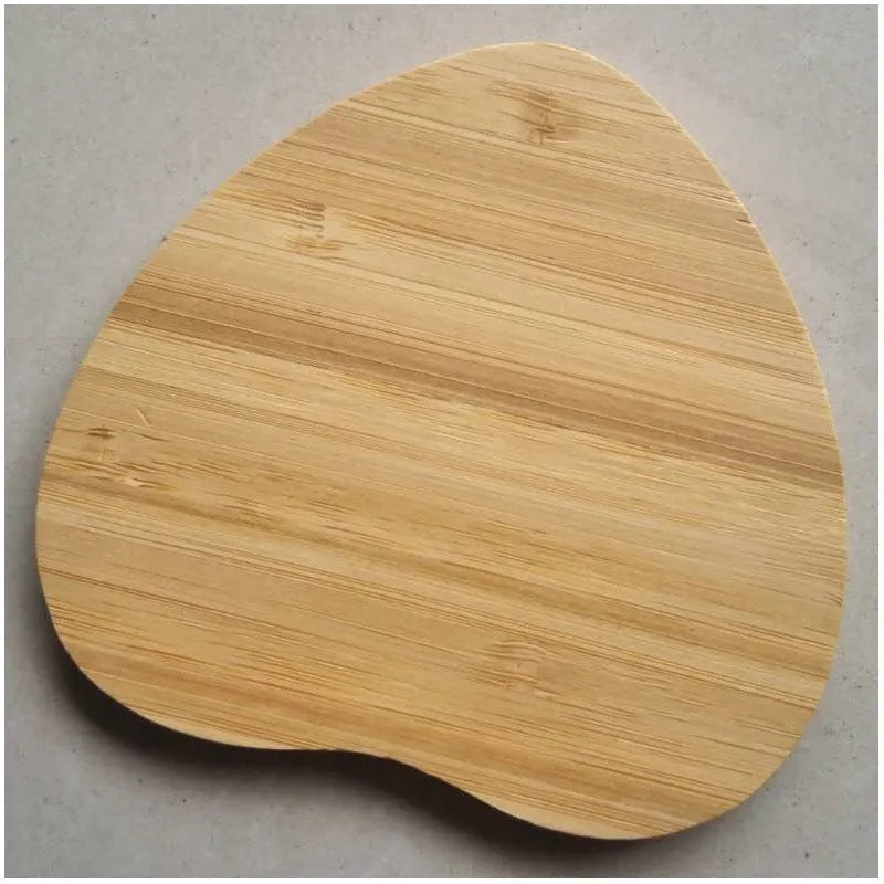 Brown heart-shaped wooden bamboo 5W Qi wireless charging pad on a desk