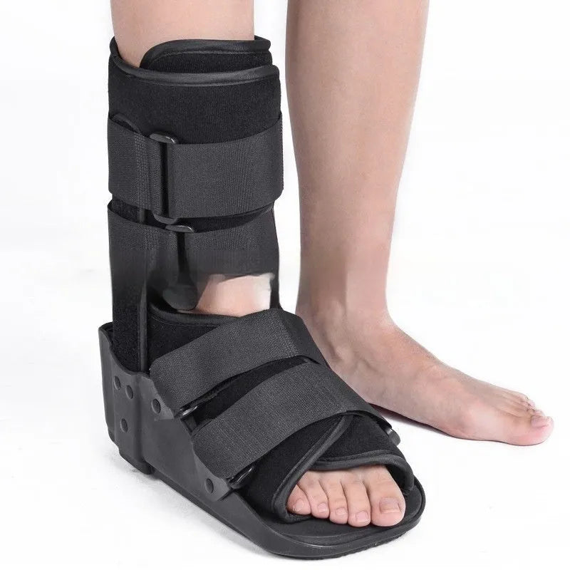 Grey Achilles tendon rehabilitation boot with aluminium frame and adjustable straps, shown with attached walking shoe.
