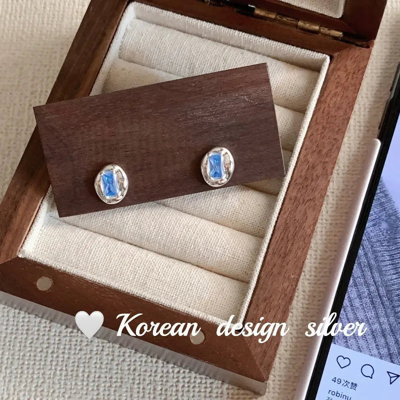 S925 sterling silver earrings with heart-wrapped oval design and blue diamond detail
