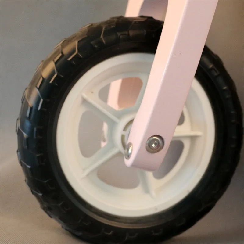 Pink wooden balance scooter for toddlers, 10 inches in size.