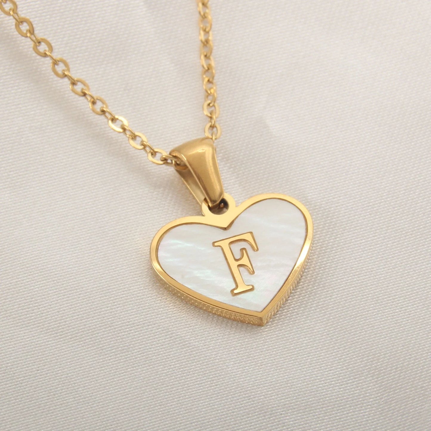 A personalized heart-shaped necklace with a 26-letter charm, crafted from high-quality stainless steel and gold plating.