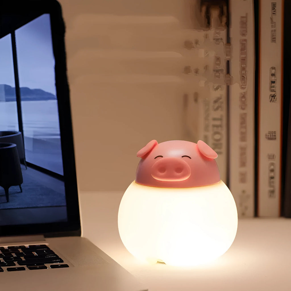 Pink pig silicone pat bedside lamp with USB LED light source on a table