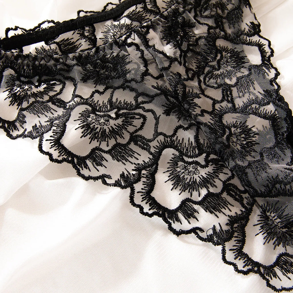 Women's black lace underwear with floral embroidery and steel ring detail on transparent polyester fabric