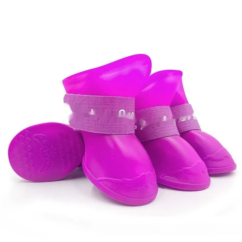 Four rubber pet rain shoes in various colours with anti-slip soles for dog paw protection