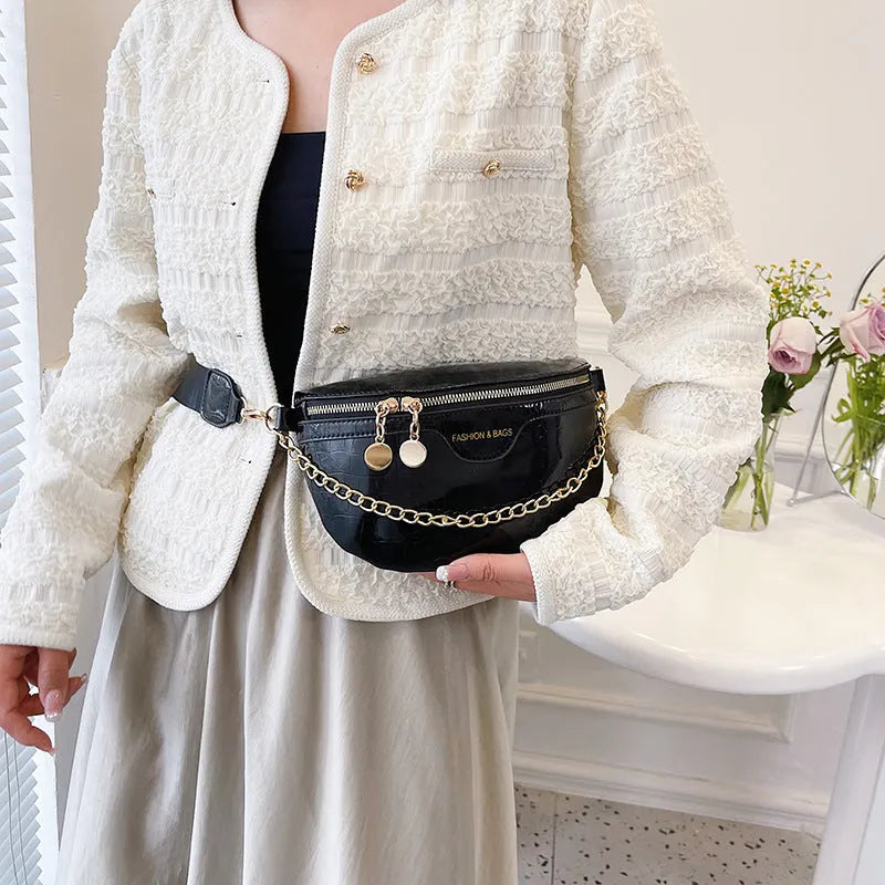 Shiny chest bag with WesternWide shoulder strap, chain detail, and hard PU shell in black colour