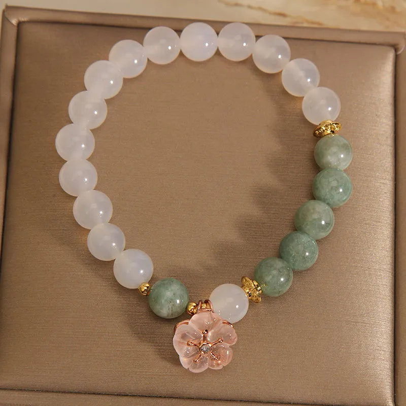 Women's white agate jade bracelet with flower design and pink accents on adjustable sliding knot closure