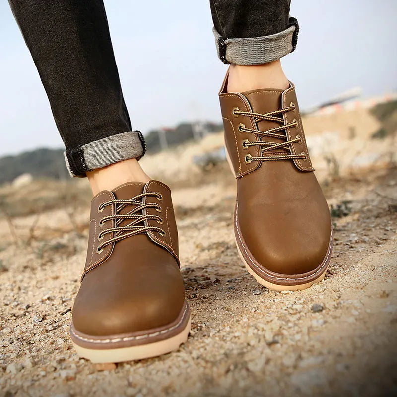 Men's black mid-top leather-style boot with a flat rubber sole.