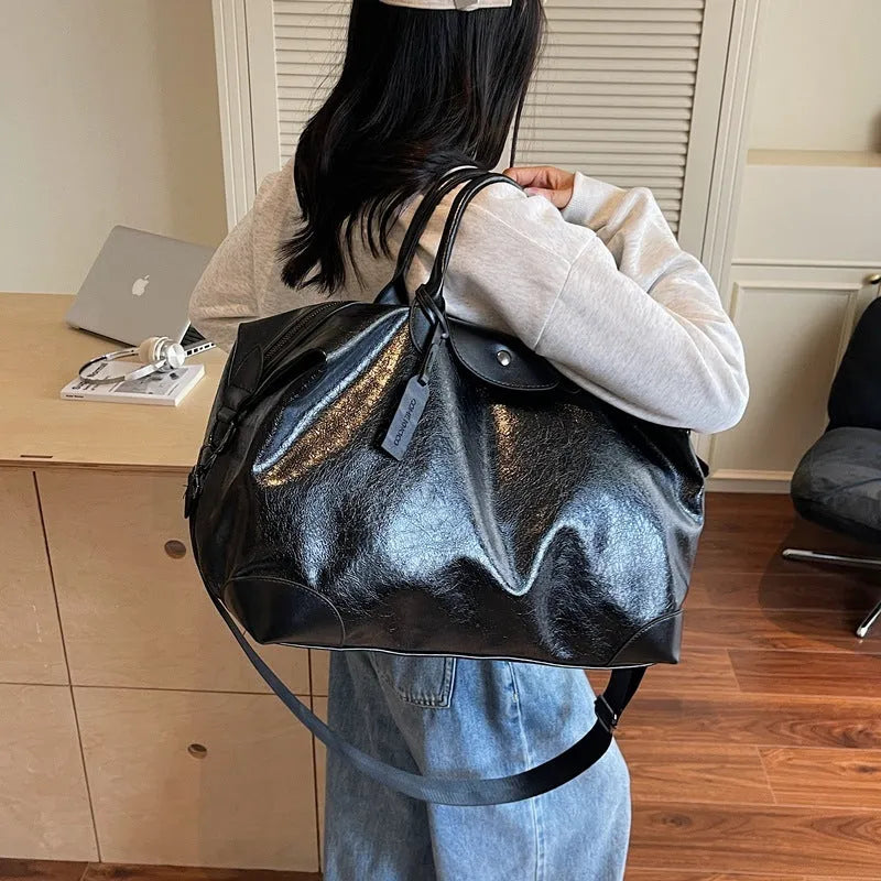 Women's large capacity hand-carry travel bag in black or silver colours with 36-55 litre volume