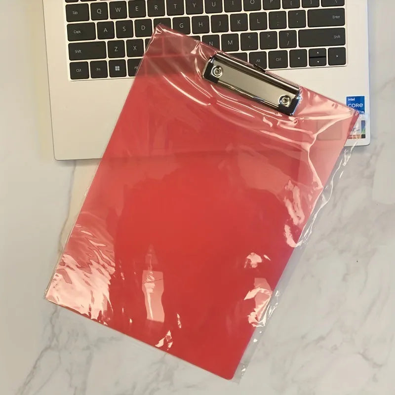Transparent A4 clipboard with metal clip, shown in blue colour on a wooden desk.