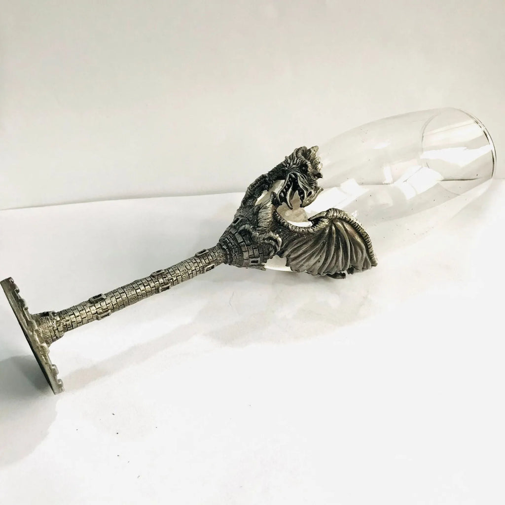 Alloy dinosaur champagne glass goblet in ancient tin colour on a surface, 21cm tall, retro style