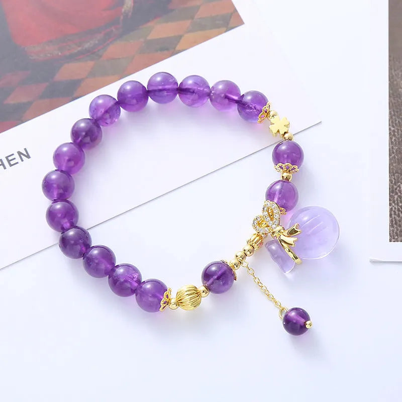 Purple crystal bracelet with geometric shapes, money bag pendant and peace buckle on wrist