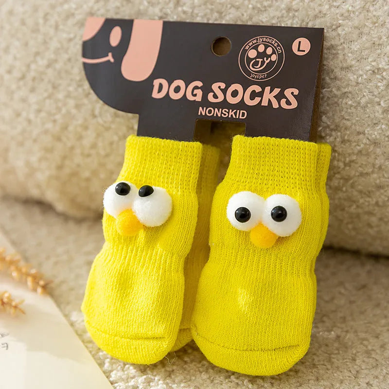Dog wearing green non-slip socks with cartoon big eyes pattern on wooden floor