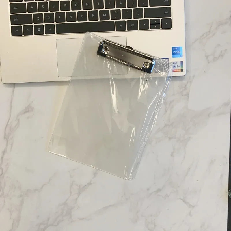 Transparent A4 clipboard with metal clip, shown in blue colour on a wooden desk.