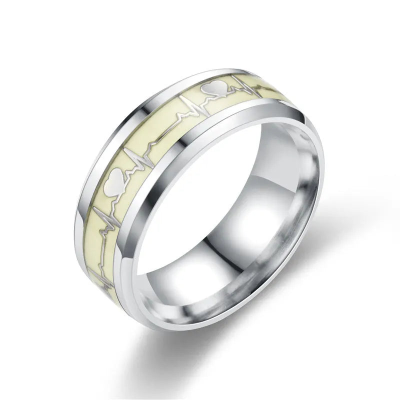 Gold heart-shaped stainless steel lovers ring with luminous glow, on white background