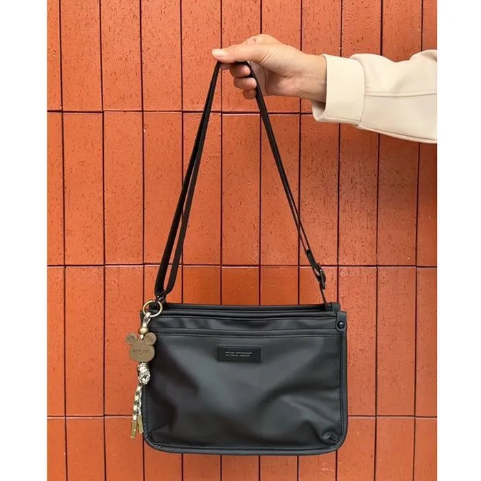 Small square crossbody bag in Oxford cloth, shown in a solid colour on an adjustable strap.