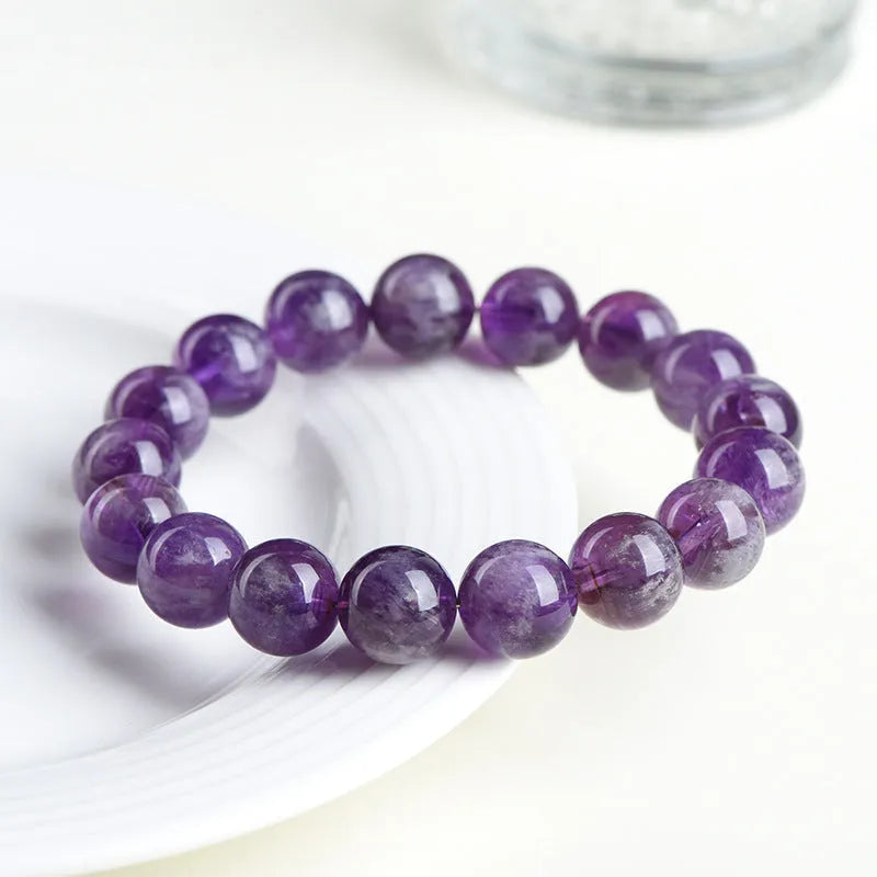 Natural Feather Amethyst purple crystal bracelet with scattered geometric beads on a wrist.