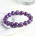 Natural Feather Amethyst purple crystal bracelet with scattered geometric beads on a wrist.