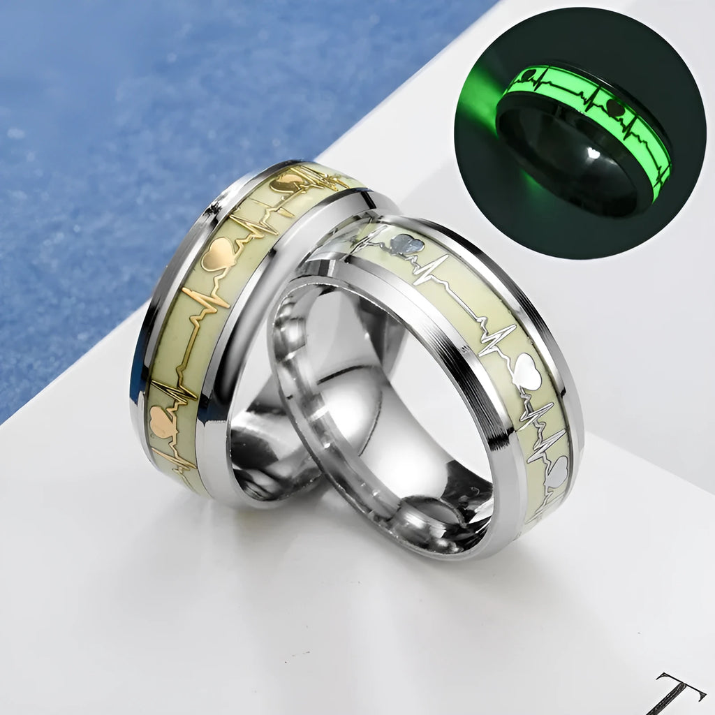 Gold heart-shaped stainless steel lovers ring with luminous glow, on white background