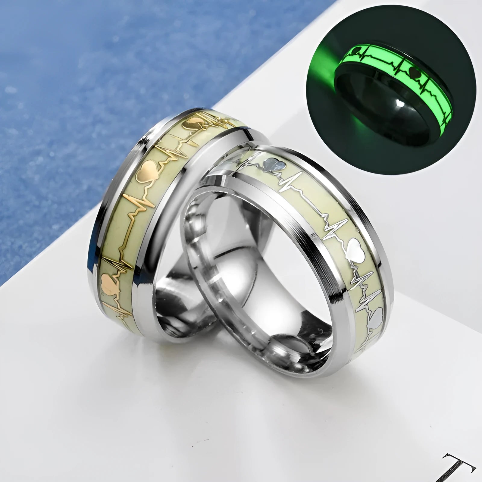Gold heart-shaped stainless steel lovers ring with luminous glow, on white background