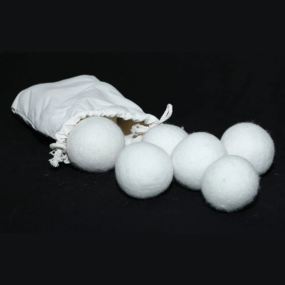 A wool drying ball for laundry next to a plain cotton storage bag on a background.