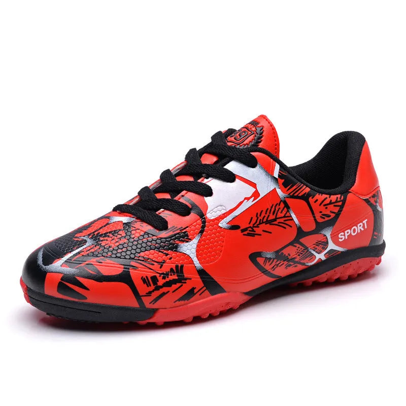 Red low-top soccer shoes with synthetic leather upper and spike outsole on natural grass