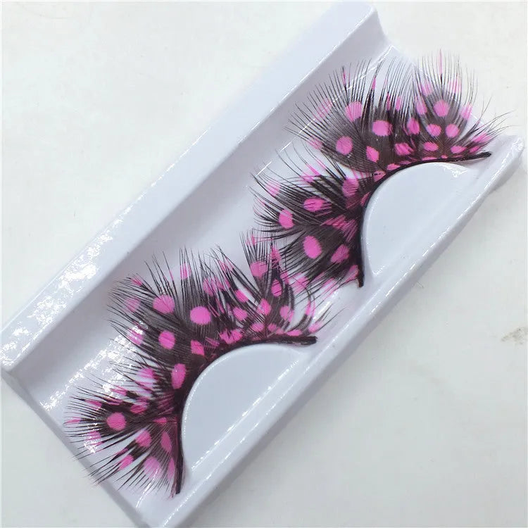 Handmade two-tone feather false eyelashes on a flat surface showing colour matching and feather texture