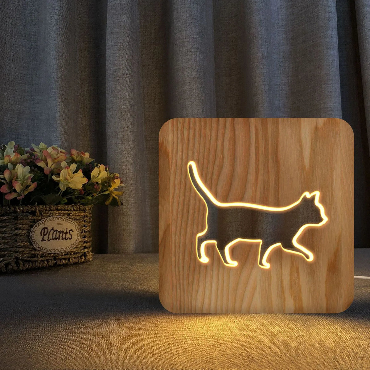Solid wood 3D night light with hollow cat design on a table