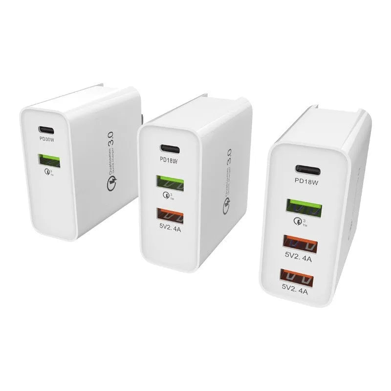 White 4-port USB fast charger with UK plug on a wooden surface.