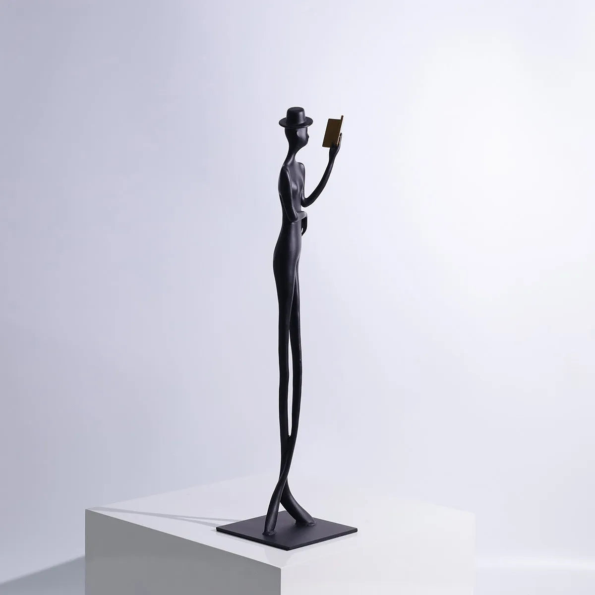 Black cast aluminium reading woman desktop sculpture measuring 51 cm tall
