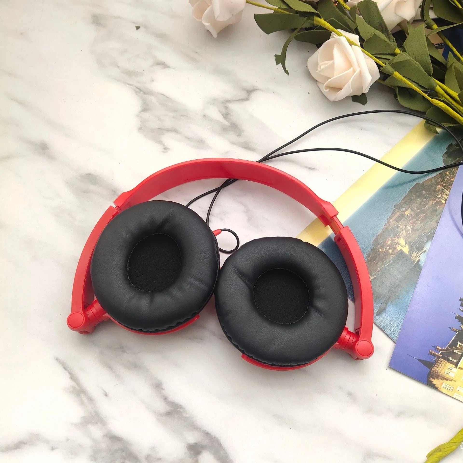 Portable over-ear wired headphones with folding design and adjustable headband in black, red or white colours