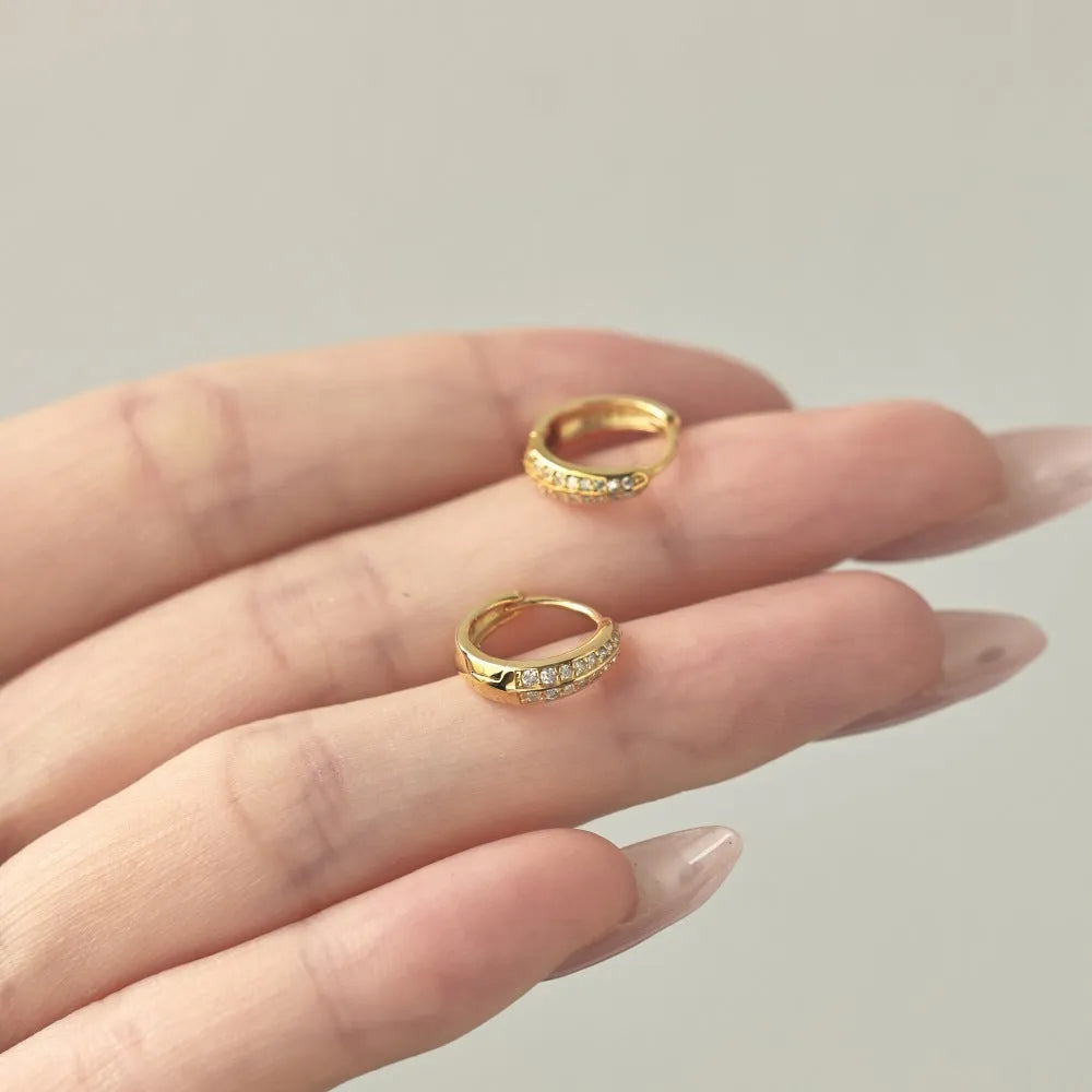 Round zircon gang drill stud earrings in 925 silver with gold electroplated finish on white background
